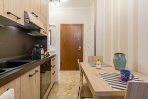 A compact kitchen with a black countertop, wooden cabinets, and a coffee maker. - Casa Al Volto (Verona)