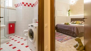 A bathroom with a washing machine, toilet, and red cabinet. - Casa Al Volto (Verona)