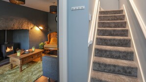 A staircase with carpeted steps and a modern light fixture. - 2 Ivy House (Corwen)