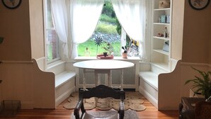 Een gezellige woonkamer met een houten vloer, een ronde tafel en een donker houten stoel.