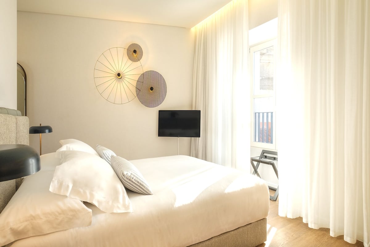 Ein modernes Hotelzimmer mit einem großen Bett, einem Flachbildfernseher und dekorativen Wandbildern.