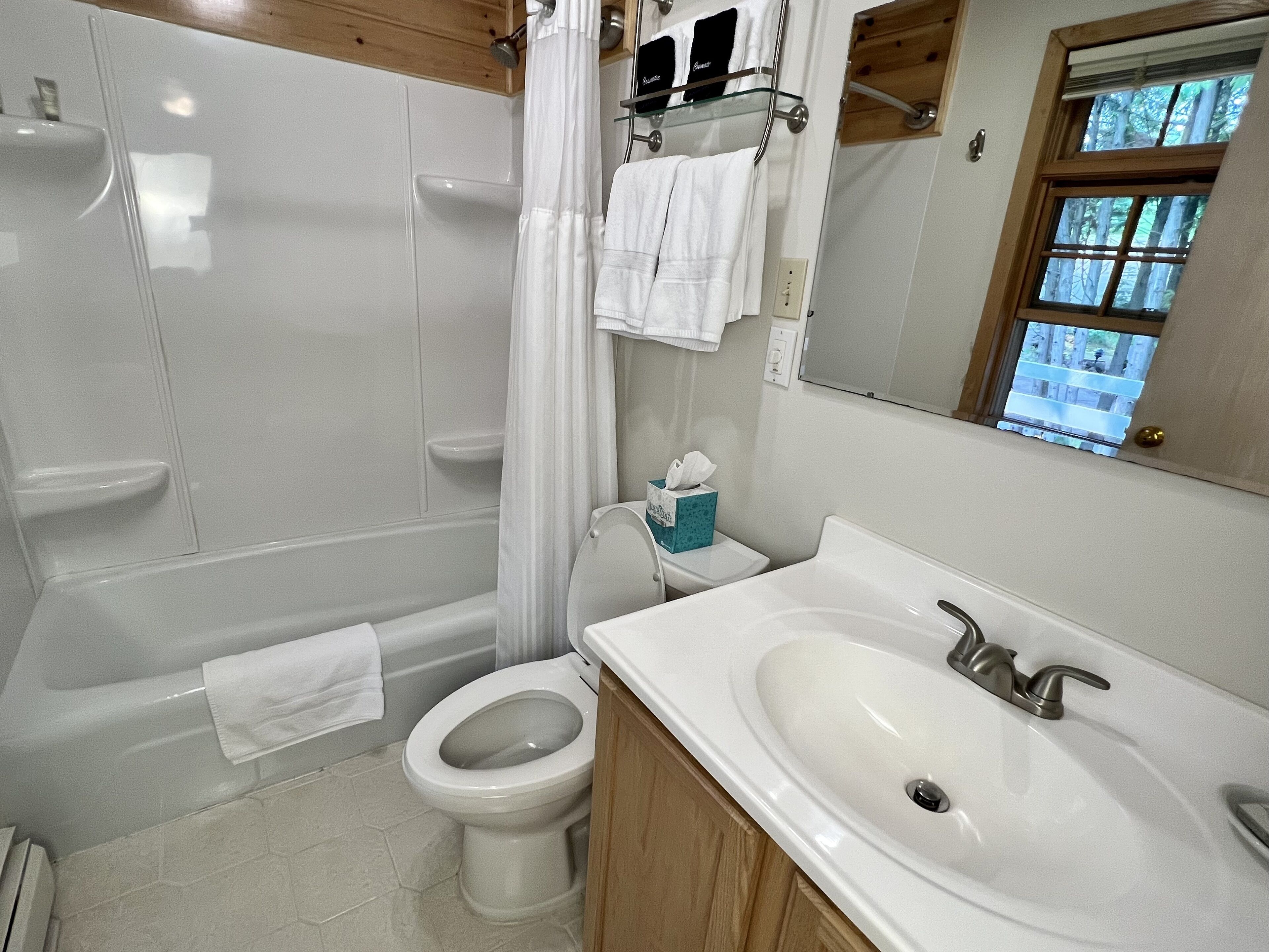 A bathroom with a bathtub, toilet, and sink.