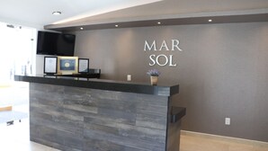 A reception desk with a grey wall and the name 'MAR SOL' in large letters. - Mar Sol (Mazatlán)