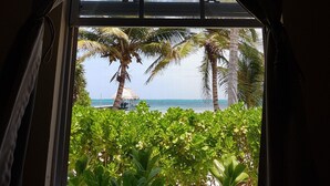 A window with a view of palm trees and a clear sky.