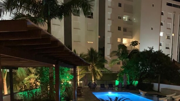 A rooftop pool area with a hot tub, lounge chairs, and potted plants. - Hotel João de Barro (Itajai)