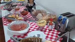A buffet table with various food items, including bread, pastries, and condiments. - Hotel João de Barro (Itajai)