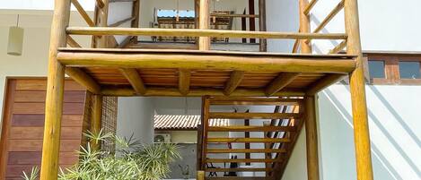 Ein zweistöckiges Gebäude mit einer Holztreppe und einem überdachten Außenbereich.