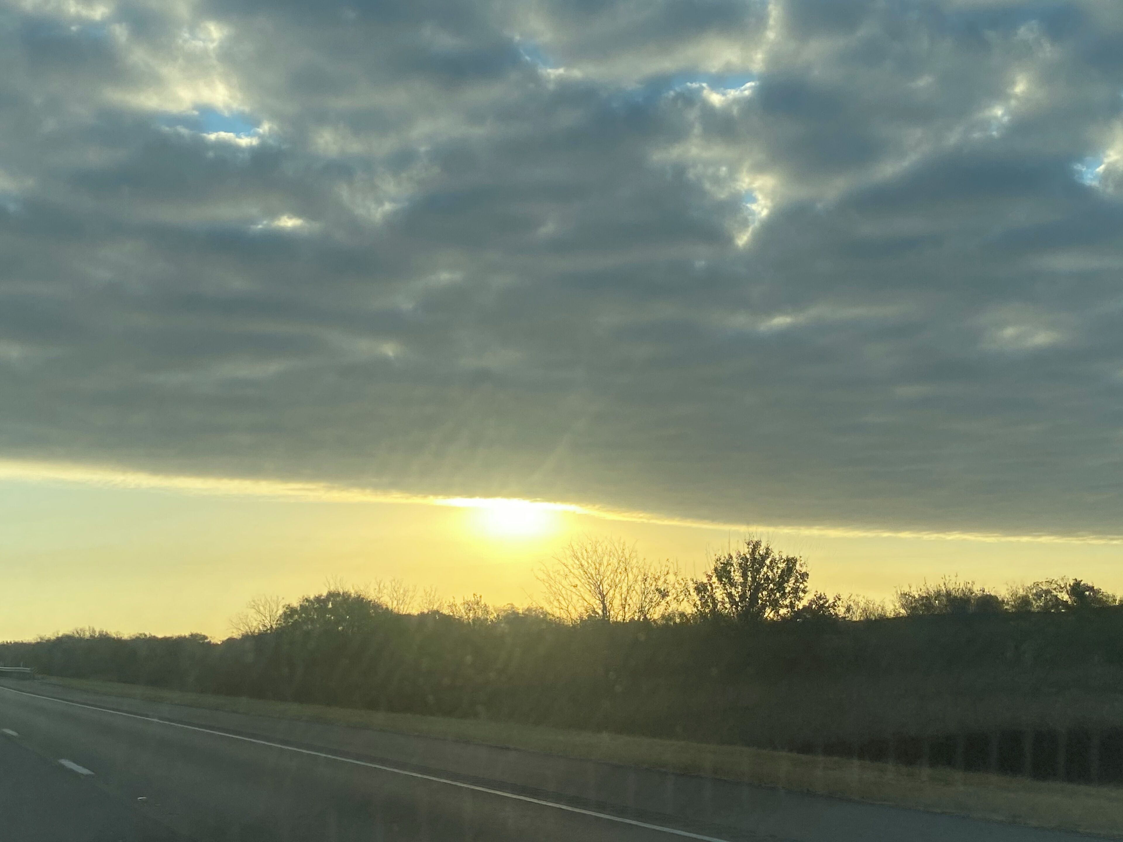 Eine Autobahn mit Sonnenuntergang im Hintergrund.