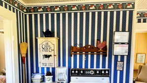 Une cuisine avec un poêle d’époque, un papier peint à rayures et une enseigne indiquant : « Lait frais de la ferme Owl Creek ».