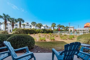 A resort with a pool area, outdoor seating, and a view of the ocean.