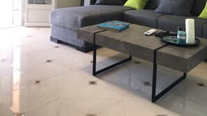 Un salon moderne avec un canapé gris, une table basse et un tableau accroché au mur.