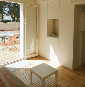 Quarto com porta de correr de vidro que dá para área externa com mesa e cadeiras.