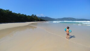 A beach with clear skies and calm waves. - Pousada Aquarela do Mar (Angra dos Reis)