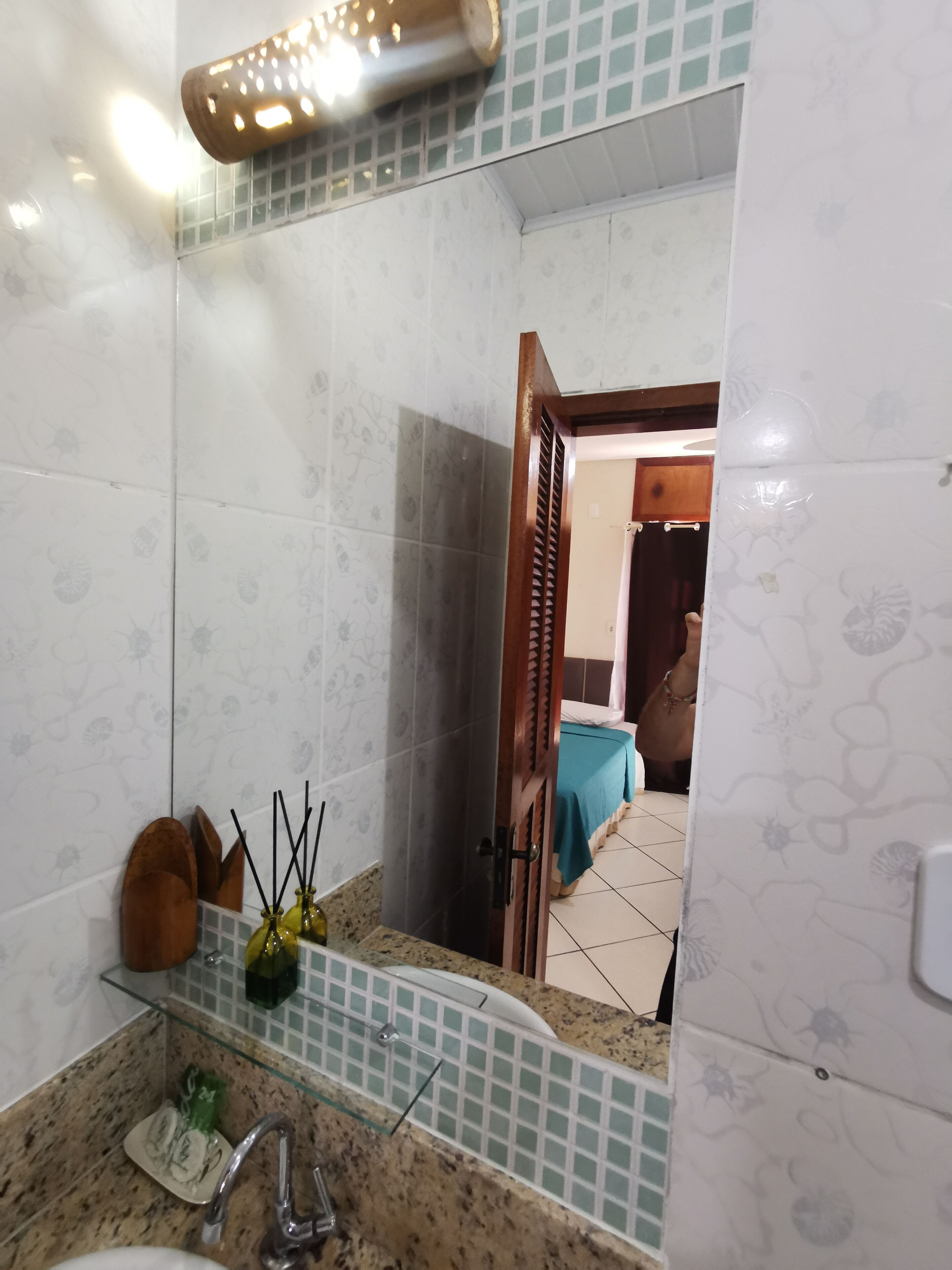 A bathroom with a sink, mirror, and a shower area.