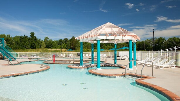 A swimming pool with a gazebo, lounge chairs, and a lifeguard stand. - One Bedroom, Luxury Condo, Williamsburg Parkside, Virginia (2629717) (Williamsburg)