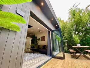 Una casa moderna con ampie vetrate e un ingresso in vetro che conduce a un soggiorno con divano e tavolino.