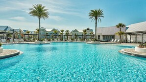 Ein großer Pool mit Liegestühlen und Palmen.