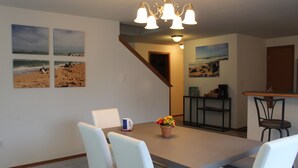 A dining area with a table and chairs, a potted plant, and a staircase leading to another room. - Canal front Island Escape for the family! Dog-Friendly with private Dock  (Ocean Shores)