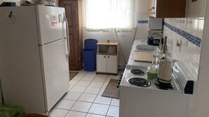Una cucina funzionale con frigorifero, fornelli, lavello e pensili.