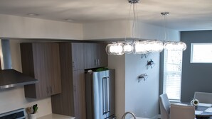 Eine moderne Küche mit Kochinsel, Edelstahlgeräten und Holzböden.