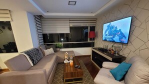 Una sala de estar moderna con un sofá, una mesa de centro y un televisor montado en la pared.
