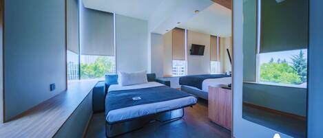 Un dormitorio moderno con cama, sofá y zona de escritorio.