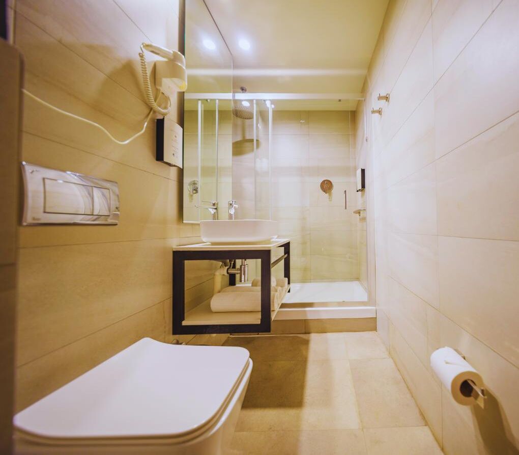 Un baño pequeño con inodoro, lavabo y ducha.