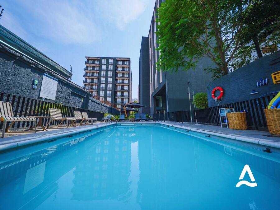 A swimming pool with lounge chairs and a lifebuoy on the right side.