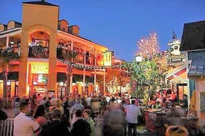 A crowded public square with buildings and a tree. - FREE GOLF CART! Stocked Lake w/ amazing views! 5 Mins. To Dining, Beach & pool. (Miramar Beach)