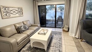 Una sala moderna con un sofá color beige, una mesa de centro y un tapete estampado.