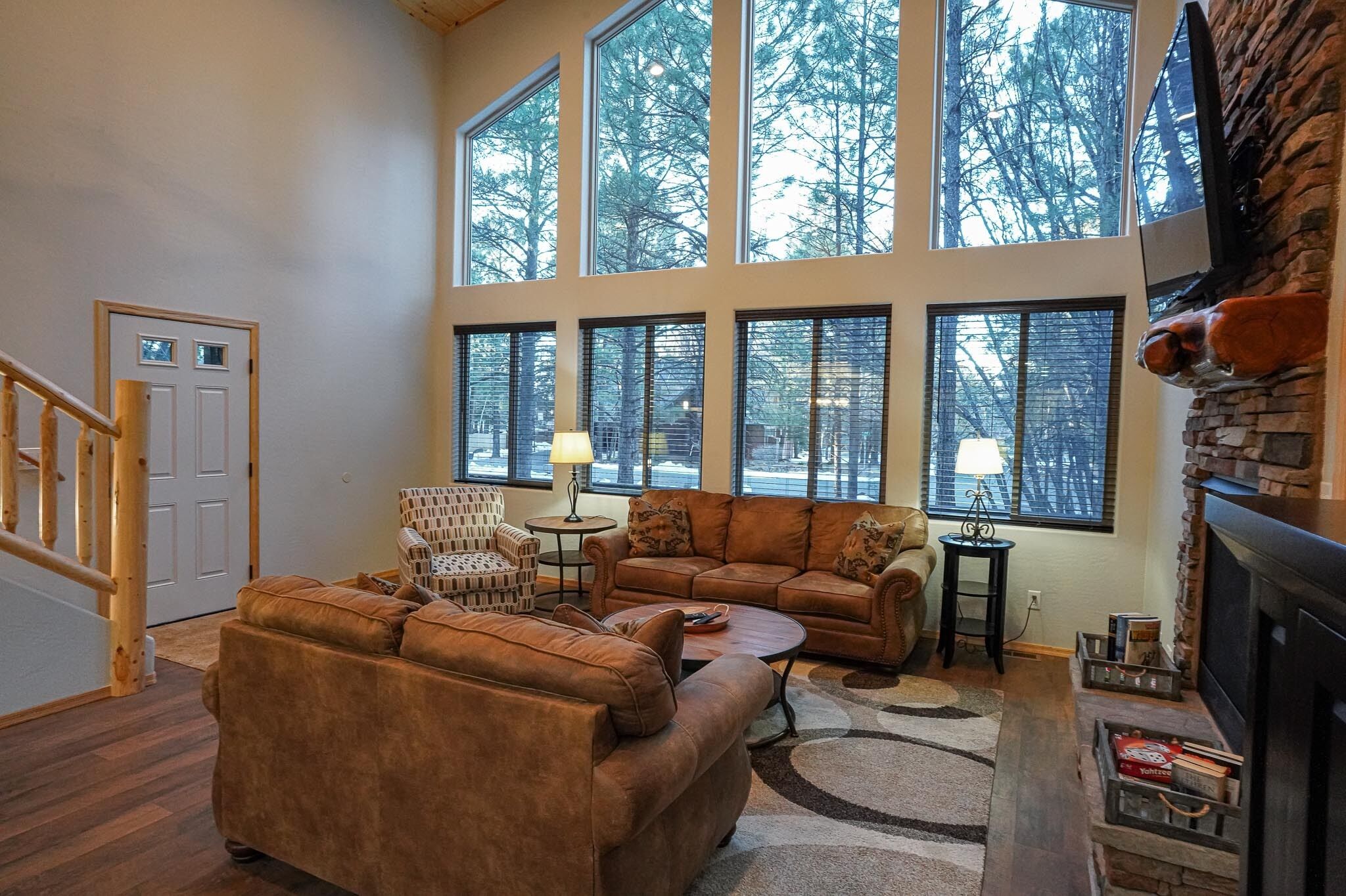A spacious living room with large windows, a fireplace, and a cozy seating area.