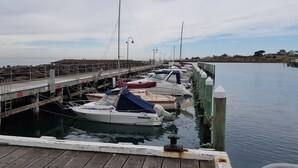 A wooden dock with boats moored at the pier.