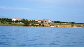 A coastal property with multiple buildings, a beach, and a clear view of the sea. - 5 minutes from the amusement park (Privlaka)