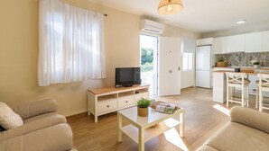 Ein modernes Wohnzimmer mit Fernseher, Sofa und Couchtisch.