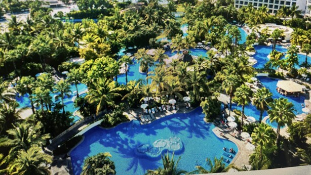 A resort with multiple swimming pools surrounded by lush greenery and palm trees. -  Vidanta Nuevo Vallarta! (Nuevo Vallarta)