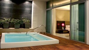 A modern indoor swimming pool with a wooden deck, a glass door leading to a bedroom, and potted plants. -  Vidanta Nuevo Vallarta! (Nuevo Vallarta)