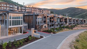 Un hôtel moderne à plusieurs étages, doté de grandes fenêtres et d’une entrée agrémentée d’un aménagement paysager.