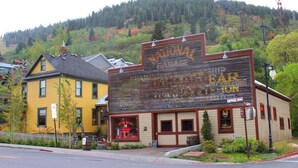 A rustic building with a large sign reading "NATIONAL BAR" and "THE WESTERN DISTRICT".