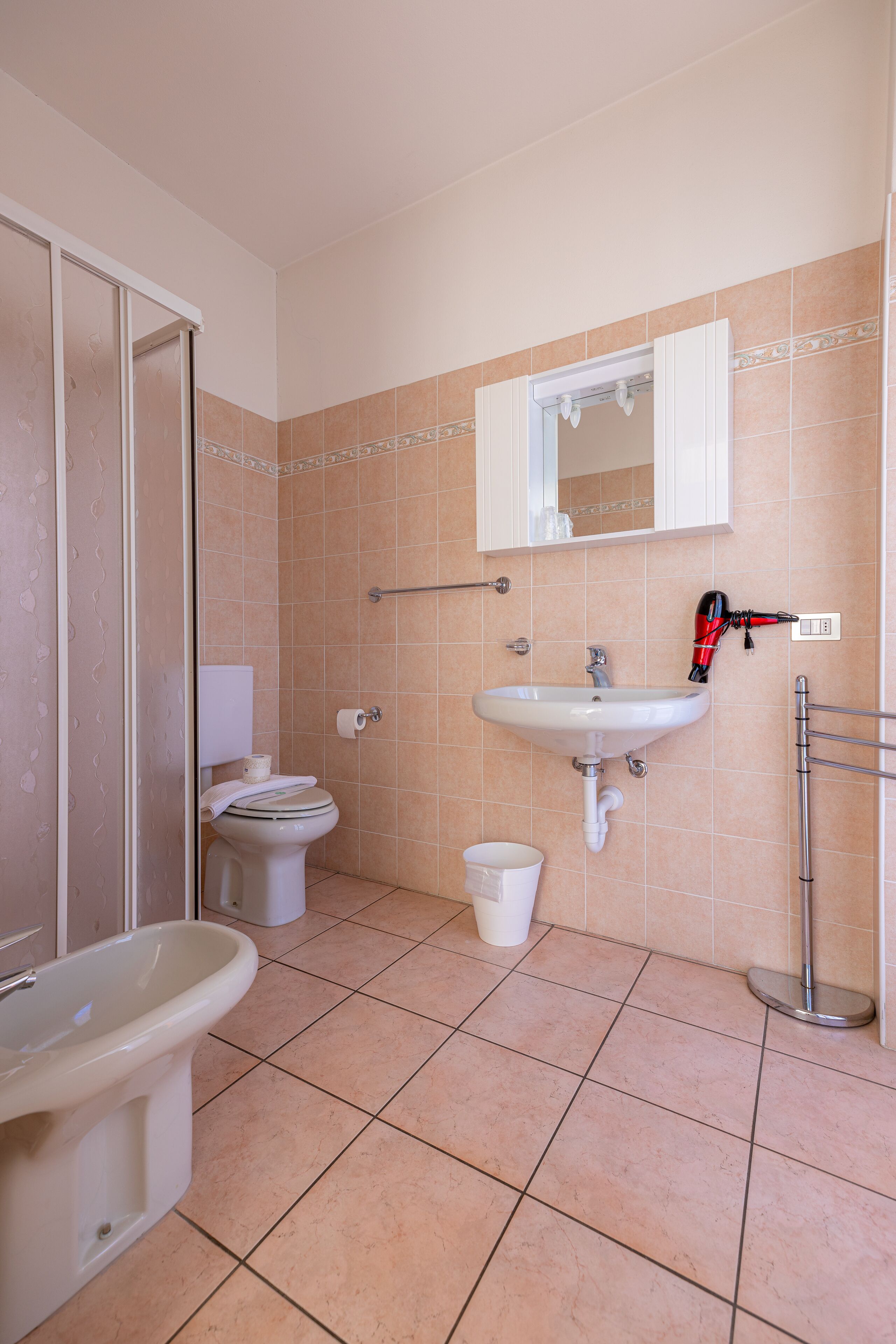 A bathroom with a toilet, sink, and bidet.