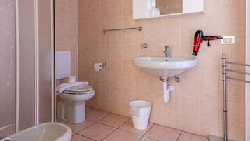 A bathroom with a toilet, sink, and bidet.