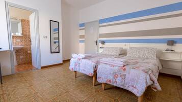 A bedroom with a bed, bedside tables, a mirror, and a door.