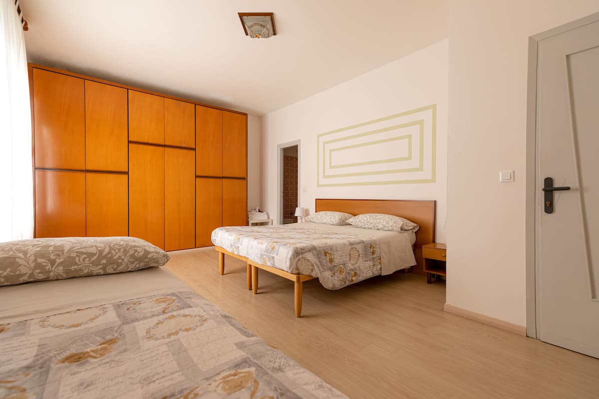 A bedroom with a bed, a wardrobe, and a door.