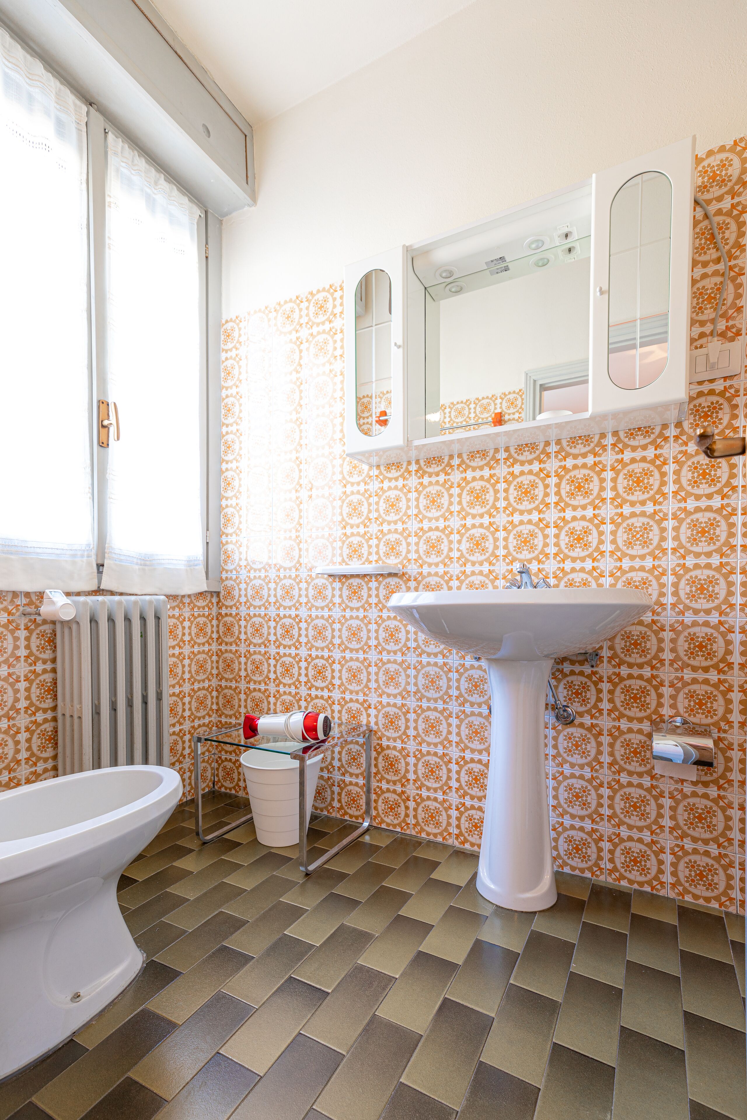 Ein Badezimmer mit Toilette, Waschbecken und Fenster.