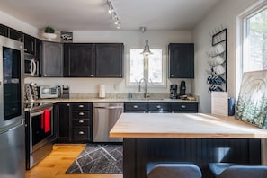 Enjoy cooking in this well-equipped kitchen with a central island, dishwasher, and coffee maker.