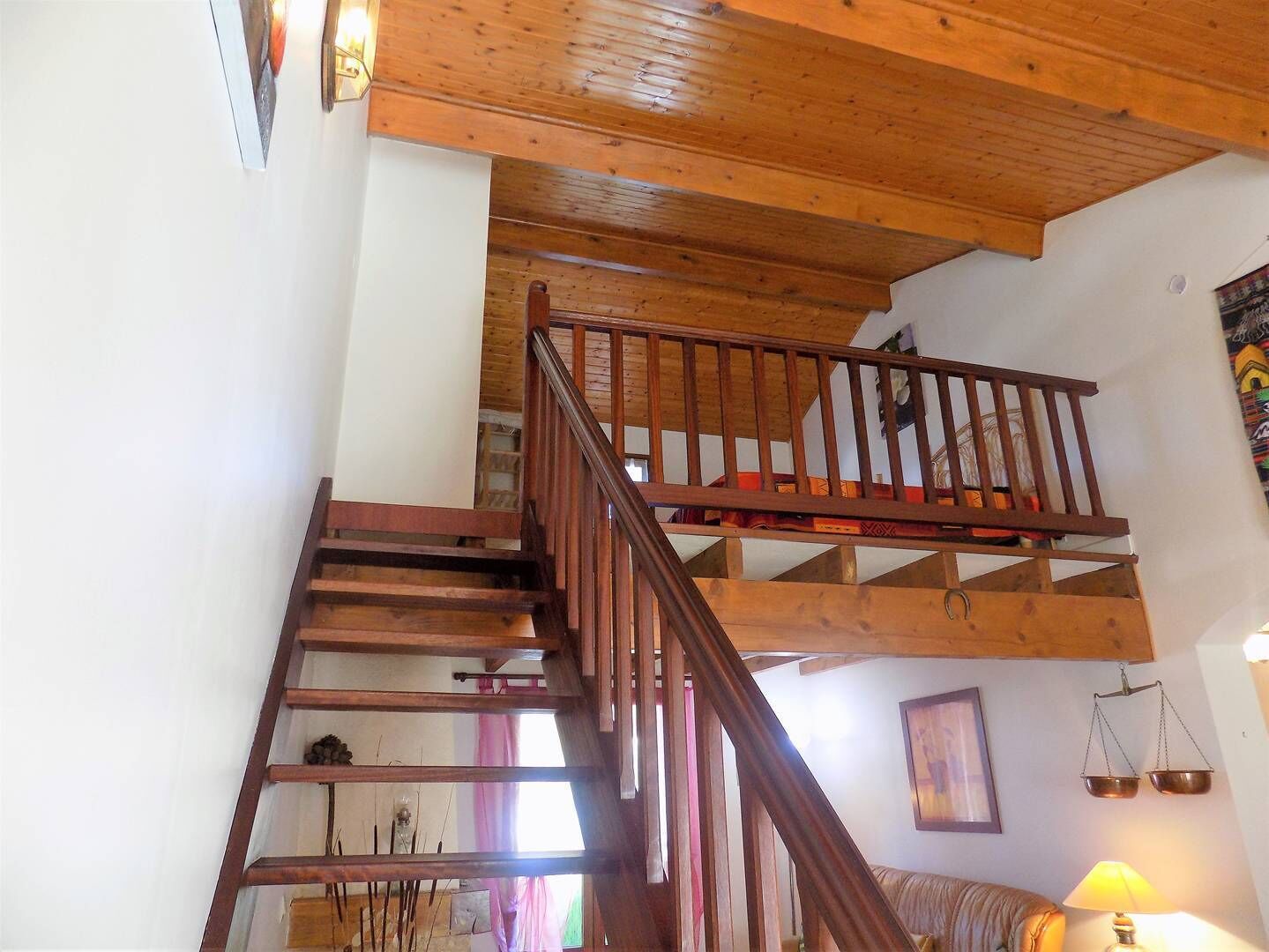 Eine Holztreppe mit Handlauf, die zu einer oberen Etage führt.