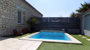 Piscina com muro de pedra e área cercada.
