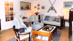A living room with a sofa, chairs, a coffee table, and a fireplace. - Les Mathes La Palmyre - CHARMING CHARENTAISE HOUSE - PEACEFUL - COUNTRYSIDE (LES MATHES)