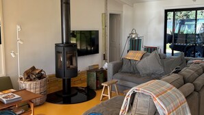 A modern living room with a large sofa, a wooden coffee table, a fireplace, and a television.