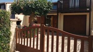 Ein Wohnhaus mit geschlossenem Eingangstor, einer Steinmauer, einem Holztor, einem Backofen und einer Garage.