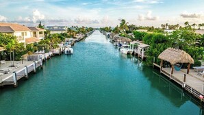 Un canal con barcos amarrados a ambos lados, rodeado de edificios residenciales y vegetación.
